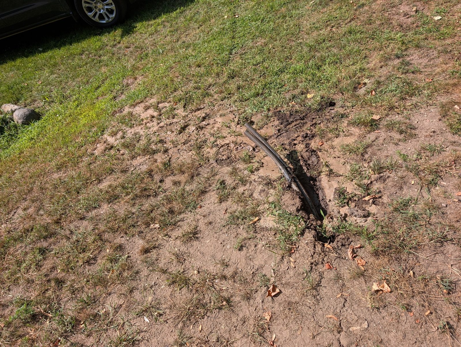 New water line emerging through a narrow slot in an otherwise untouched lawn